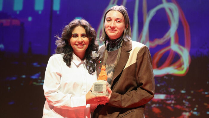 Leela Varghese and Emma Hough Hobbs pose together with their Teddy Award on the Berlinale stage.